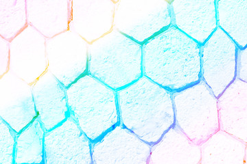 Empty colorful wall made of different sizes rocky hexagons with copy space. Background with rainbow colors.