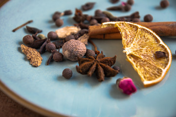 Dried oriental spices for making drinks on a home ceramic plate. Home kitchen.