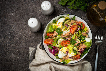 Tuna salad with green leaves, eggs and vegetables.