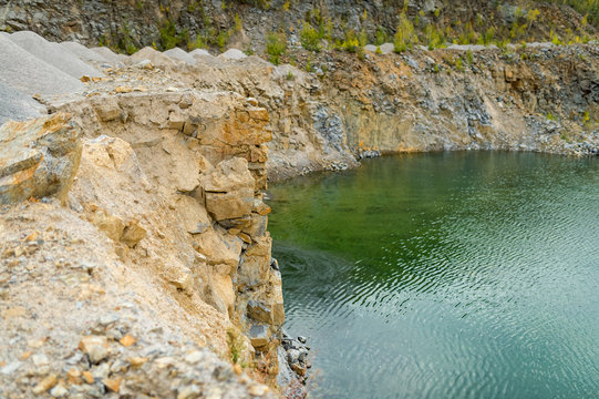 flooded pit mining or quarry with beautiful blue water. Side view panoramic photo.