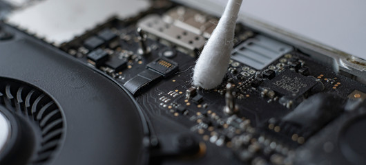 macro view of removing dust from microprocessor board using the cotton bud
