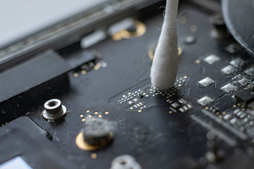 macro view of removing dust from microprocessor board using the cotton bud