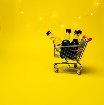 Mini Shopping Cart Full Of Small Alcohol Bottles Yellow Background