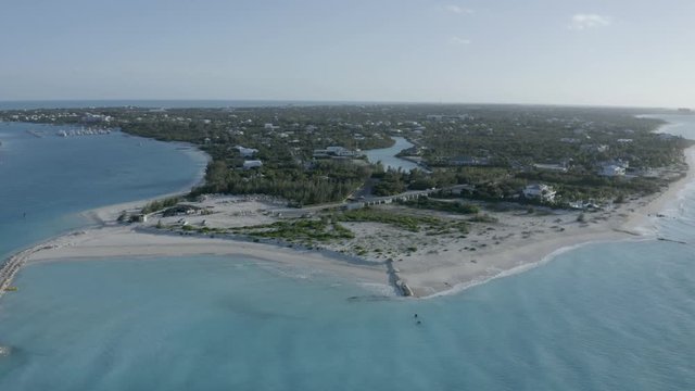 Aerial view of the beach with turquoise ocean on Turk and Caicos Caribbean Island, Providenciales. Flying above the ocean, white beach, turistic resort. Drone footage from left to right