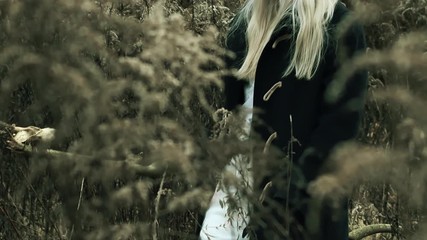 Queen of nature walking through branches with skull on wooden stick