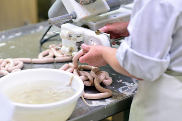 Herstellung von Würstchen in einer Fleischerei am Fliessband