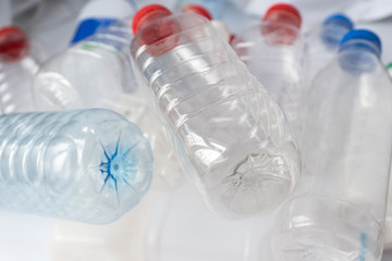 close up photo of transparent plastic bottles with caps of different colors, plastic pollution concept