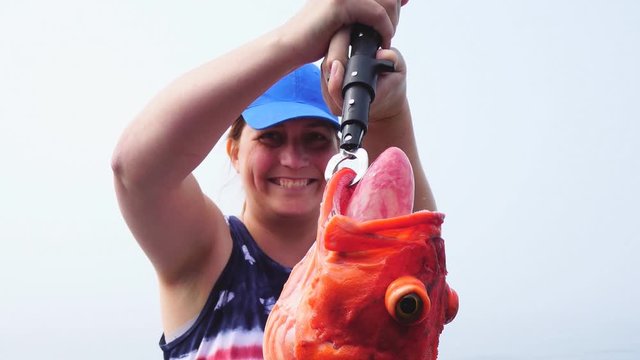 Woman fishing in Alaska holding Alaskan Rockfish
