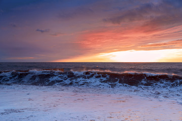 Obraz premium The evening sea is stormy. Sea sunset. The violence of the elements. Sea foam. Incredibly beautiful colors.
