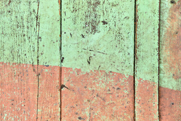 Wooden shabby fence painted in light green and beige color. Texture, background