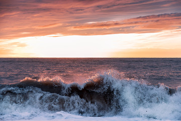 Sea sunset. Waves roll on the shore. The violence of the elements. Sea foam.