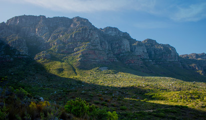 Sunlight popping over mounatins at sunrise in nature in Camps Bay.