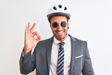 Young handsome business man wearing bike helmet and sunglasses over isolated background doing ok sign with fingers, excellent symbol