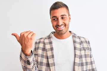 Young handsome business man wearing elegant jacket over isolated background smiling with happy face looking and pointing to the side with thumb up.