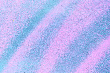 Abstract metal texture with a spray can of pink and blue paint.
