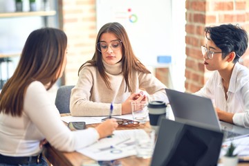 Beautiful businesswomen smiling happy. Sitting with smile on face working using laptop at the office