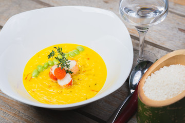 Traditional rice with seafood, risotto with rice and shrimp in a deep white plate on a table in a restaurant.
