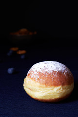 Krapfen on a dark blue background with pretzels as side decor