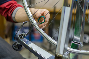 Professional repairing bicycle in modern workshop, closeup. Wheel Truing Stands