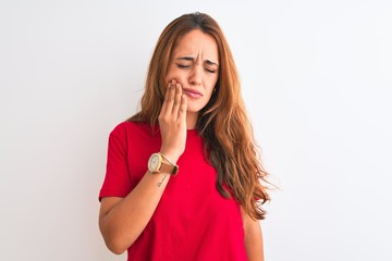 Young redhead woman wearing red casual t-shirt stading over white isolated background touching mouth with hand with painful expression because of toothache or dental illness on teeth. Dentist concept.