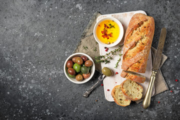 Loaf of healthy bread with spicy oil and olive