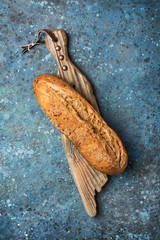 Loaf of fresh wholegrain bread on wooden board