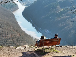 Relaxbank auf einem Berg mit Blick auf enen Fluß mit Ruhenden