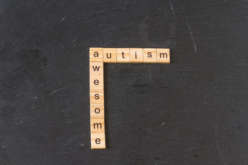 Autism and Awesome crossed in wood letter blocks.