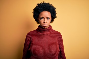 Fototapeta na wymiar Young beautiful African American afro woman with curly hair wearing casual turtleneck sweater depressed and worry for distress, crying angry and afraid. Sad expression.