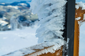 A fence covered by snow and ice at Carpathian mountains background, Zakhar Berkut peak, Ukraine.