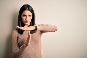 Young brunette woman with blue eyes wearing casual sweater over isolated white background Doing...