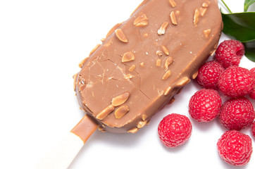 Chocolate ice cream with nuts, on a stick and a raspberry lying nearby. Concepts of healthy, tasty, nutrition.