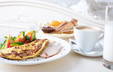 Close-up of tray with tasty breakfast on a bed.