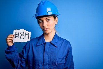 Beautiful worker woman wearing hardhat and uniform celebrating 8th march womens day with a confident expression on smart face thinking serious