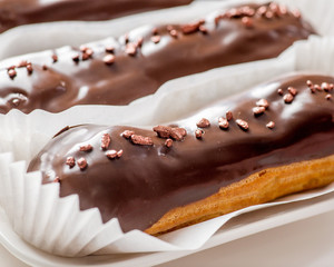 chocolate eclairs with icing and powder.Сlose-up