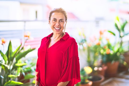 Middle age beautiful woman smiling happy and confident standing with a smile on face at terrace