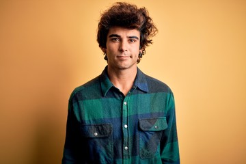 Obraz premium Young handsome man wearing casual shirt standing over isolated yellow background looking sleepy and tired, exhausted for fatigue and hangover, lazy eyes in the morning.