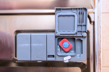 A tablet of a detergent for washing dishes in dishwashing machine container
