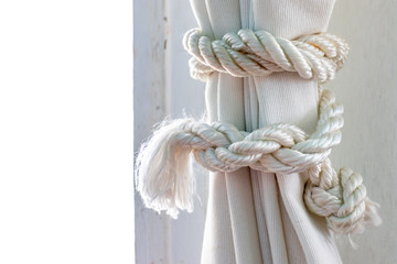 Knob of the white rope on a fabric curtain close up, copy space