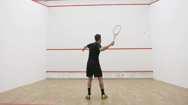 A portrait of a young bearded man practicing to play squash