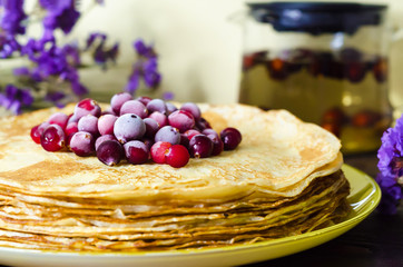 Cranberry berries in powdered sugar on stack of thin pancakes closeup. soft focus