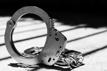 Police Handcuffs with Bars in Shadows