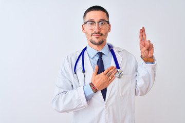 Young doctor man wearing stethoscope over isolated background smiling swearing with hand on chest...