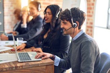 Group of call center workers smiling happy and confident. Working together with smile on face using headset at the office.