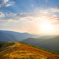 mountain ridge silhouette in a blue mist at sunset