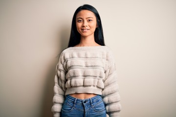Young beautiful chinese woman wearing casual sweater over isolated white background with a happy and cool smile on face. Lucky person.