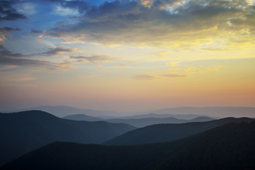 Fototapeta na wymiar mountain ridge silhouette in a blue mist at the twilight