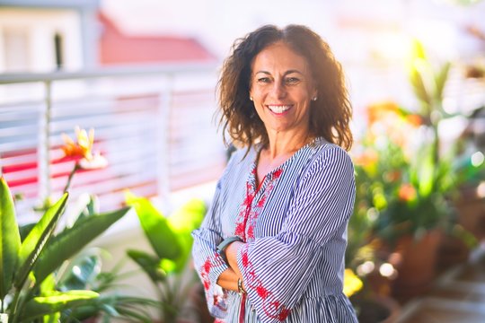 Middle age beautiful woman smiling happy and confident standing with a smile on face at terrace