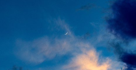 blue sky with clouds and quarter moon