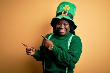 Plus size african american woman with braids wearing green hat with clover on st patricks day...